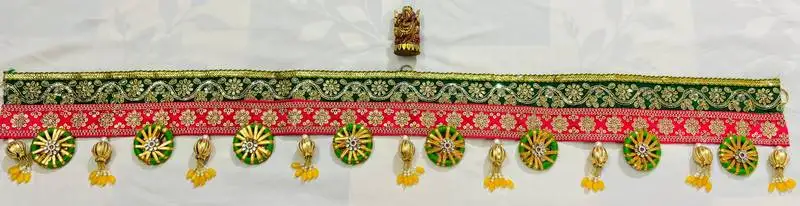 Traditional decorative door toran with green & red lace, golden embellishments, and beaded tassels