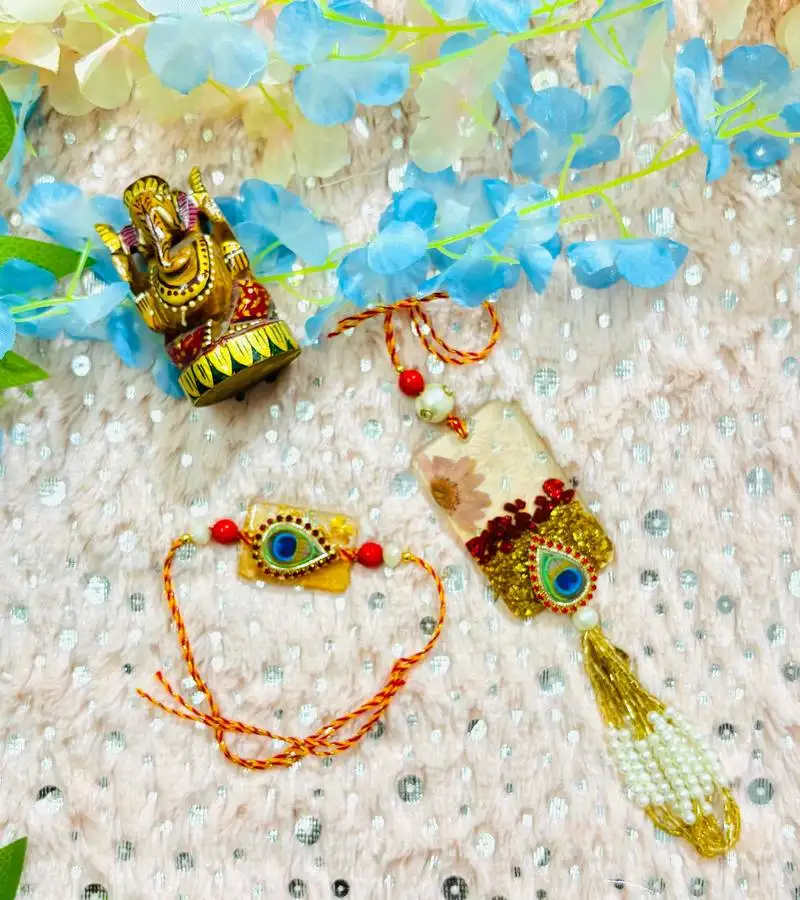 Peacock eye bhaiya bhabhi rakhi set with resin floral charm and beaded tassel