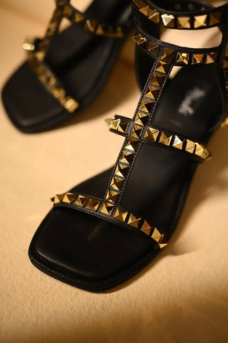 Gold studded black heels with ankle straps