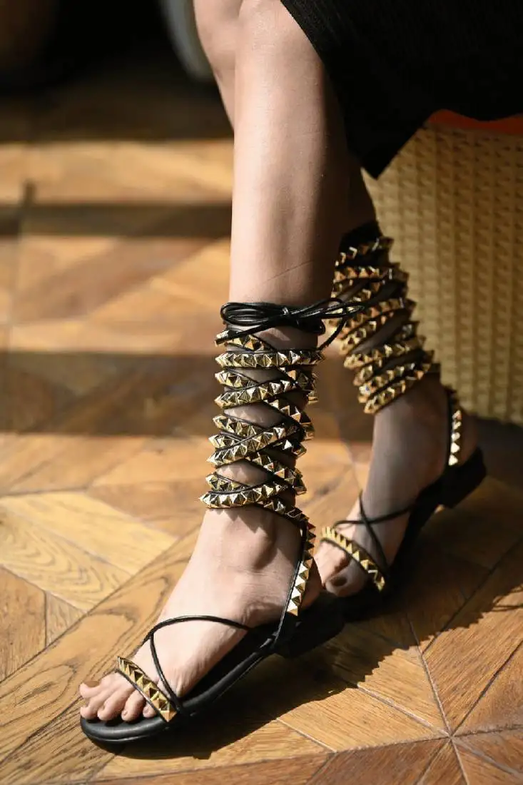 Black with long tie-up flats with gold studs.