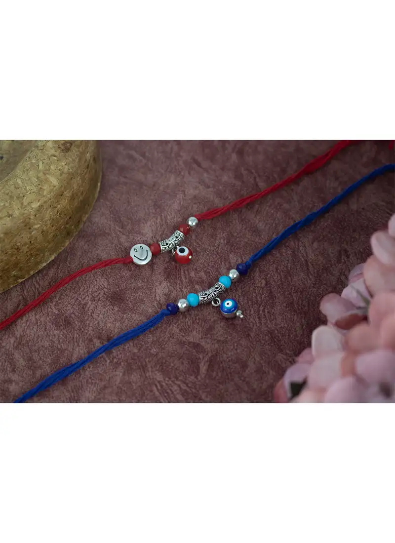 Combo of evil eye and smiley charm unisex rakhi for bhaiya bhabhi with roli chawal and written greeting note.