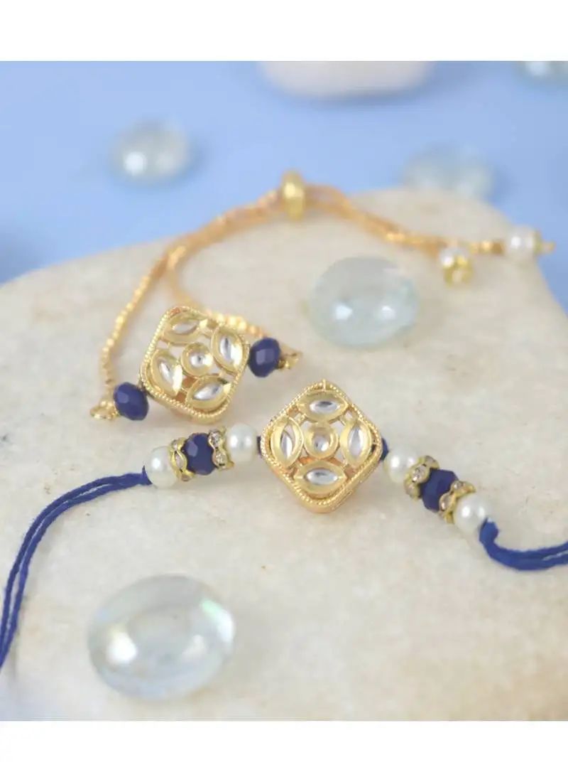 Gold-plated set of 2 handmade unisex rakhi for bhaiya bhabhi with roli chawal and written greeting note.