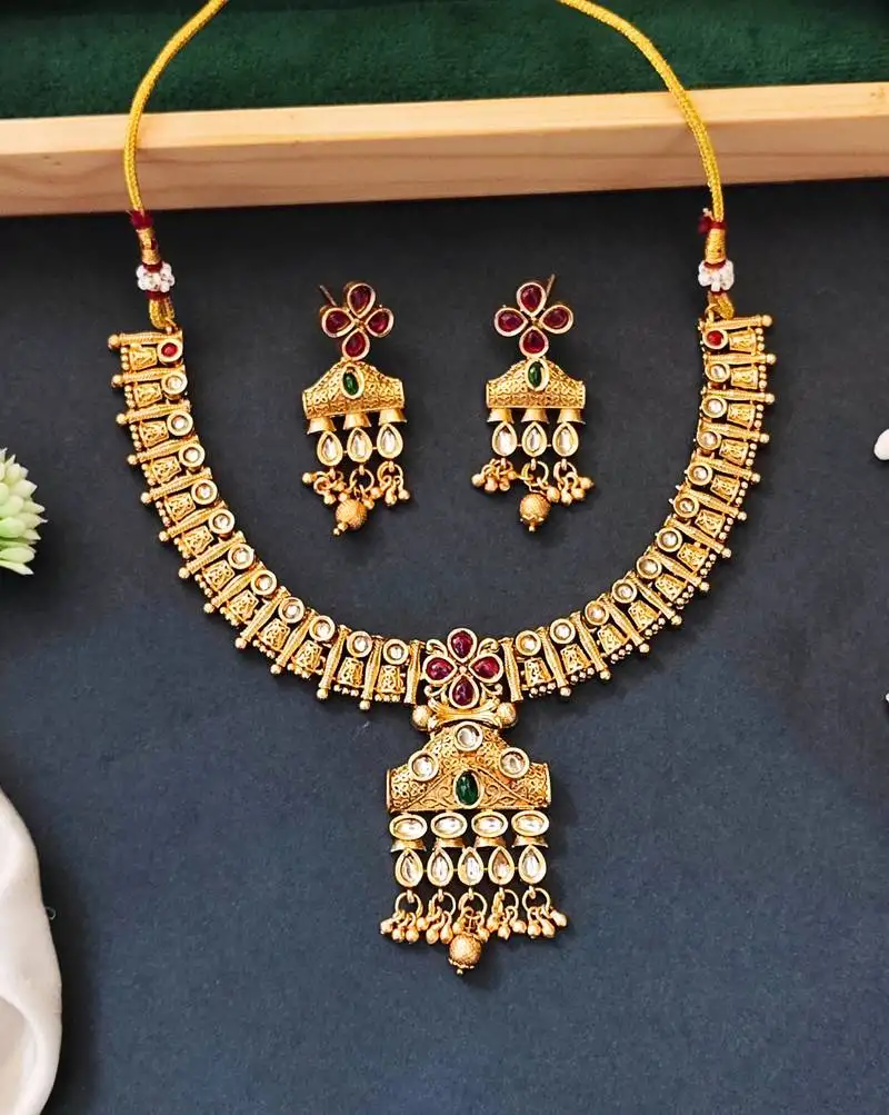 Traditional floral pendant necklace set with red and green stones and dangling beads