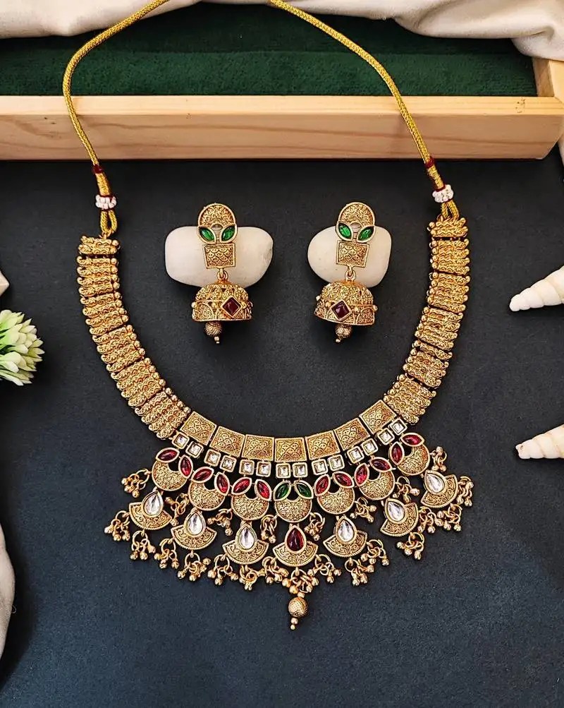 Traditional kundan choker necklace set with red and green stones, gold-plated jhumka earrings