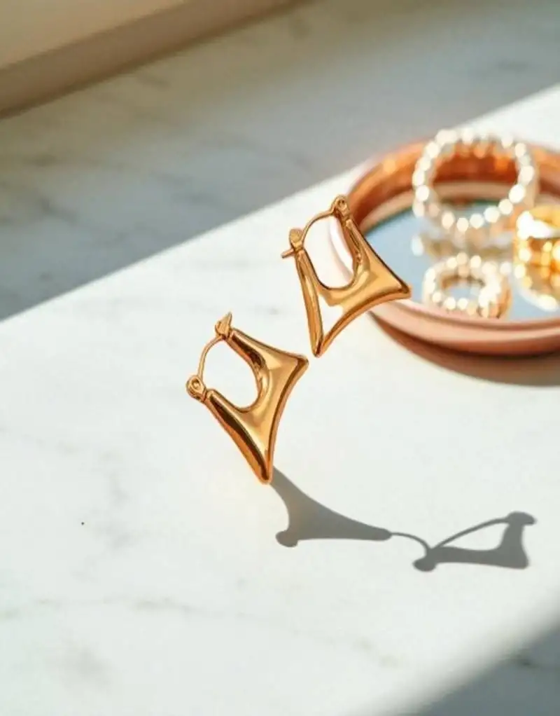 Golden glamouranti tarnish sleek triangle hoop earrings