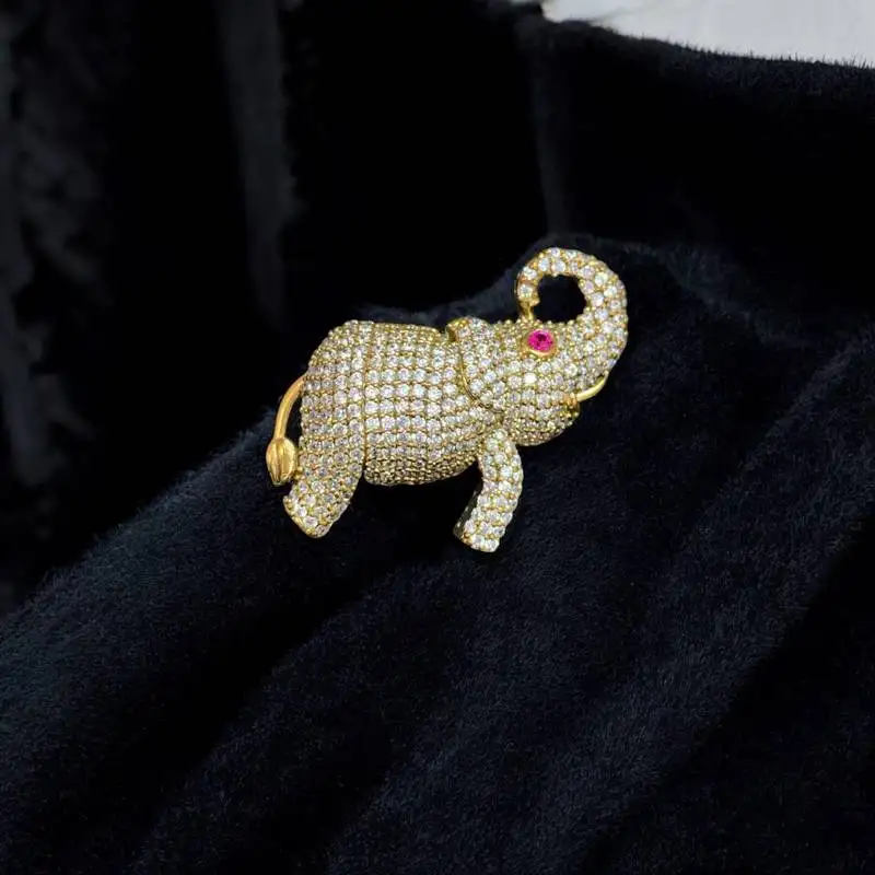 Gold-toned crystal elephant brooch with ruby eye accent