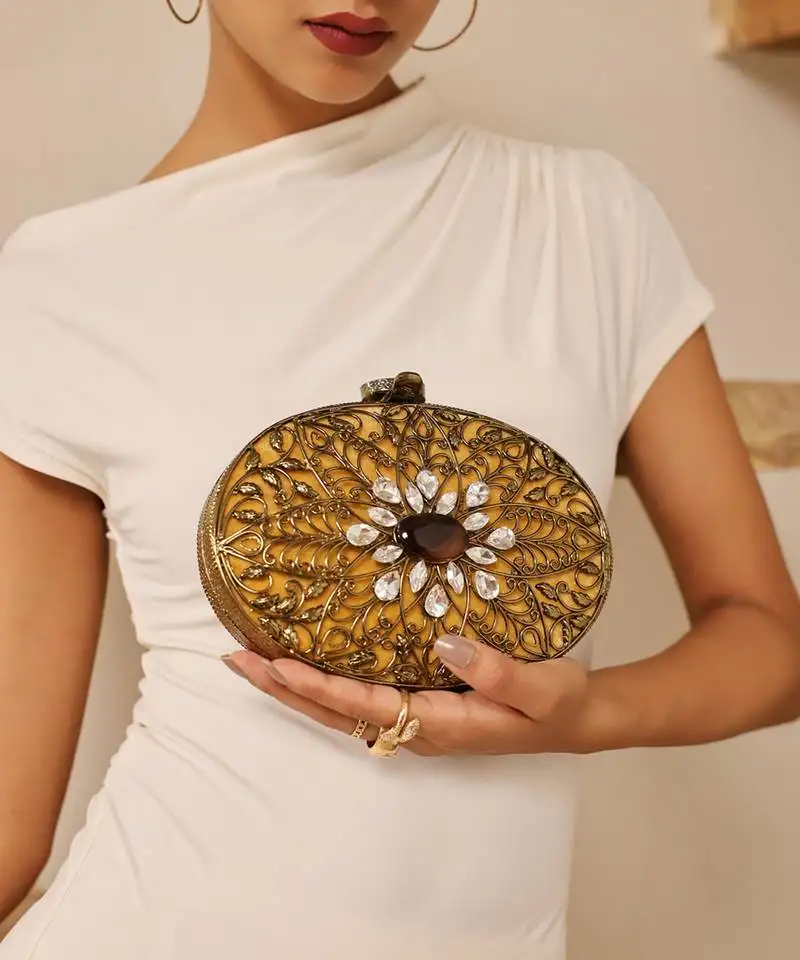 Gold embellished brass clutch with inticrate work