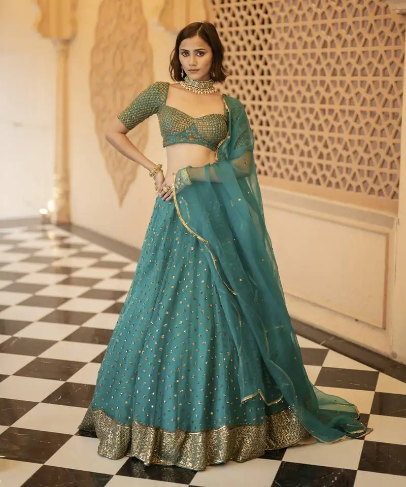 Teal green organza base embellished with nakshi and sequnce lehenga set