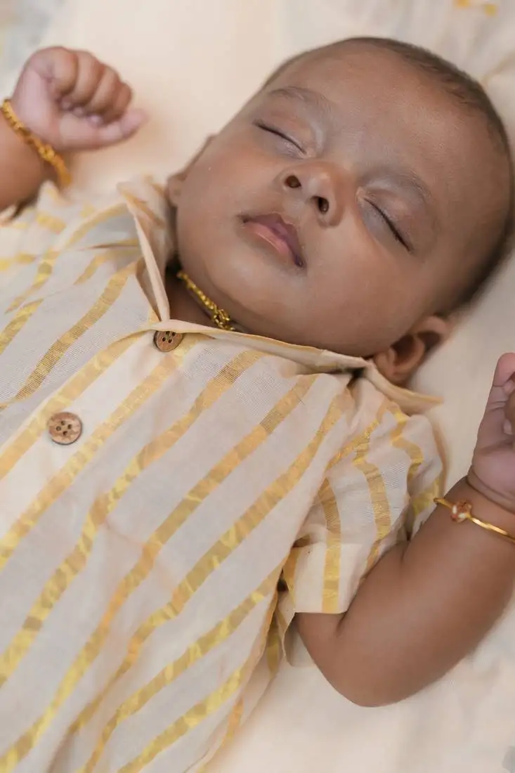 White cuban shirt romper with golden kasavu stripes and short sleeves.