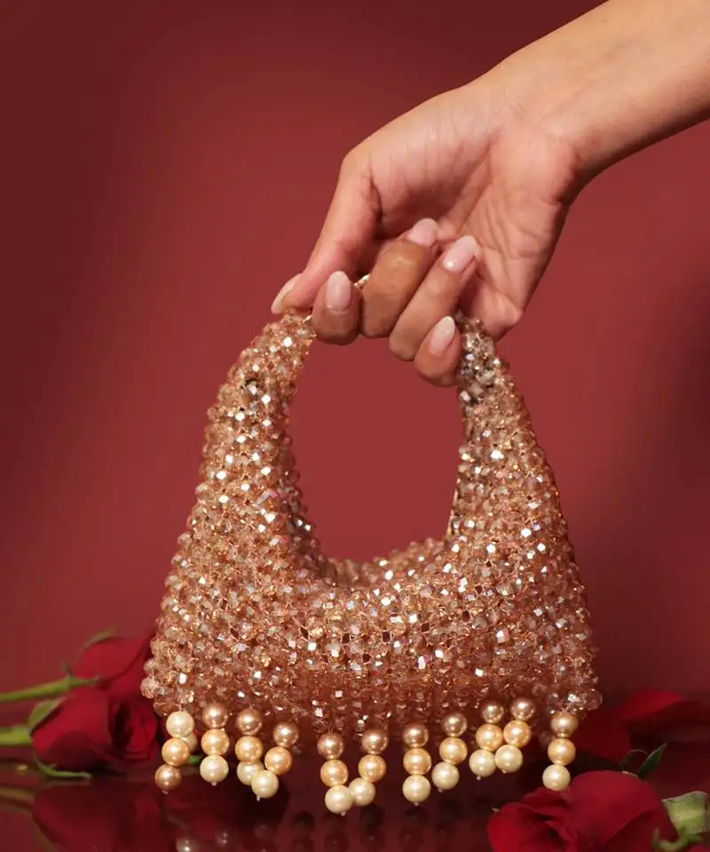 Gold potli bag with crystal work and pearl hangings