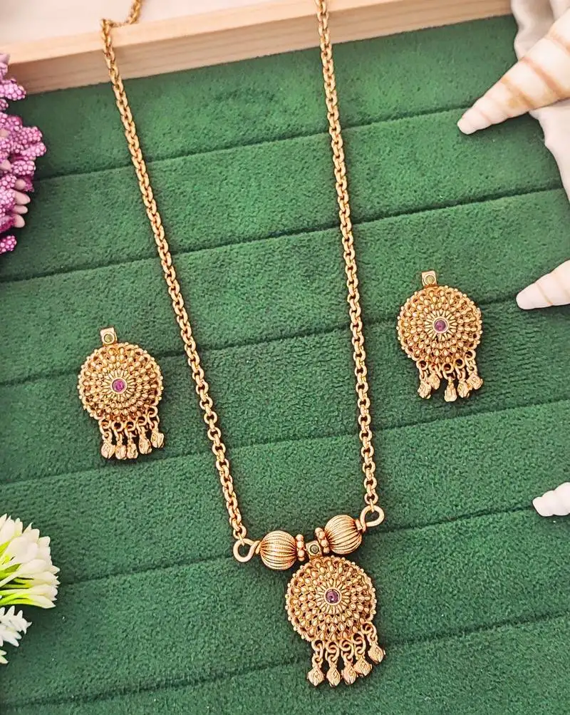 Traditional gold-plated pendant set with earrings, featuring red and green stones