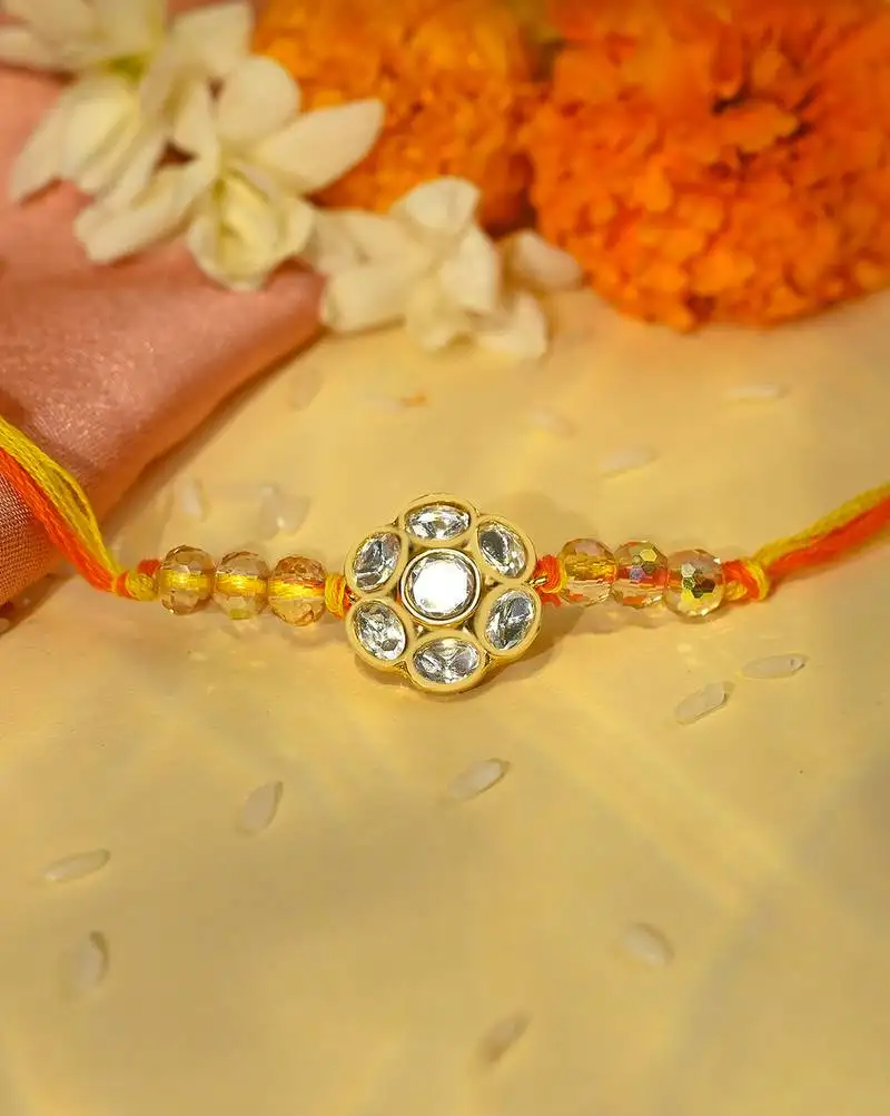 Yellow thread rakhi with floral stone motif and crystal beads