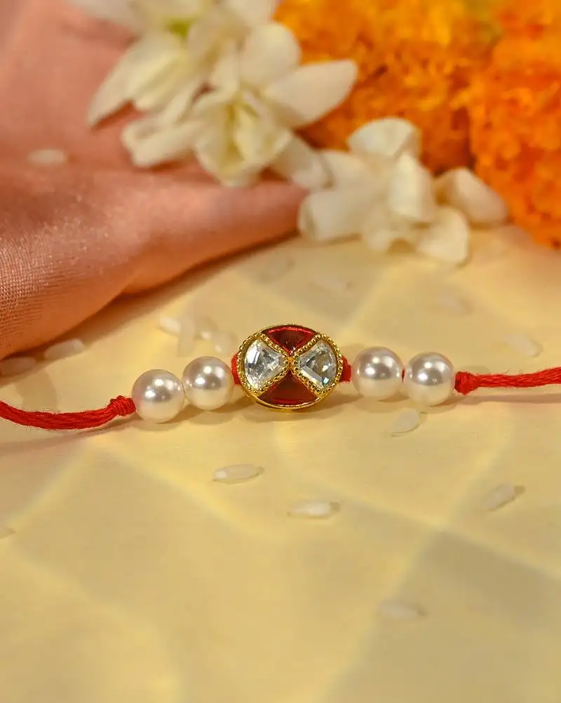 Red thread rakhi with oval dual stone charm and pearl beads