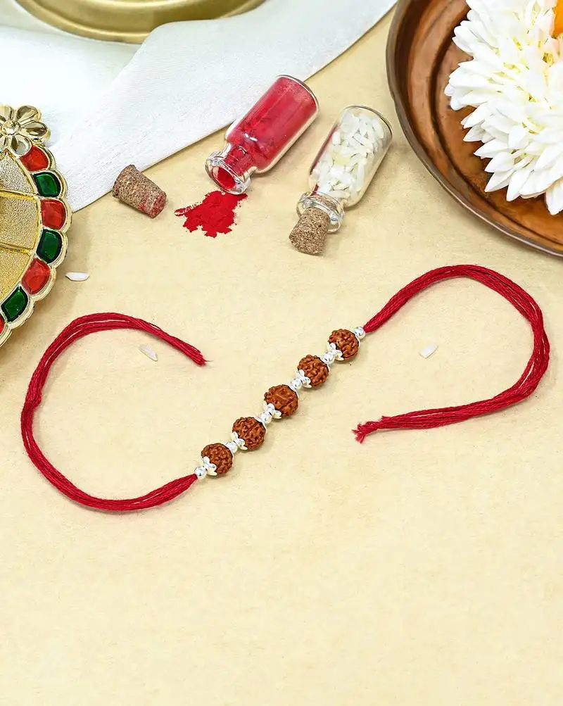 Red thread rakhi with five rudraksha beads and silver detailing