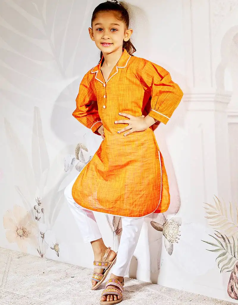 Girl's traditional raksha bandhan outfit - orange cotton kurta with white leggings set for casual festival wear